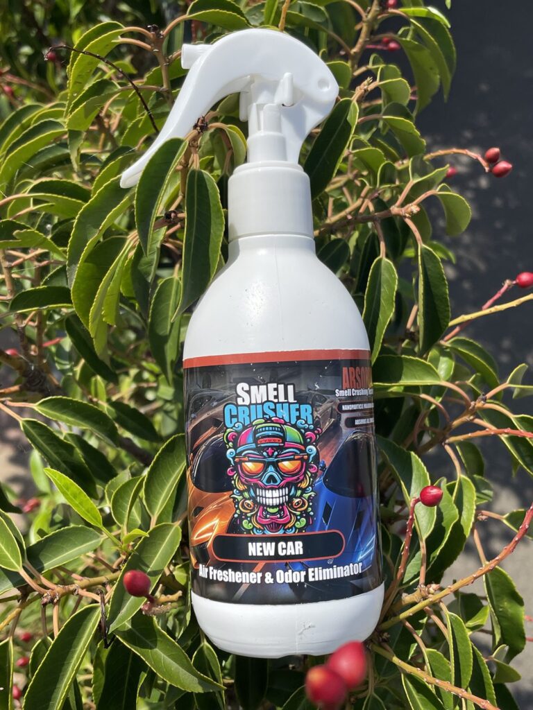 Smell Crusher Absorber Spray New Car odor eliminator in front of green leaves