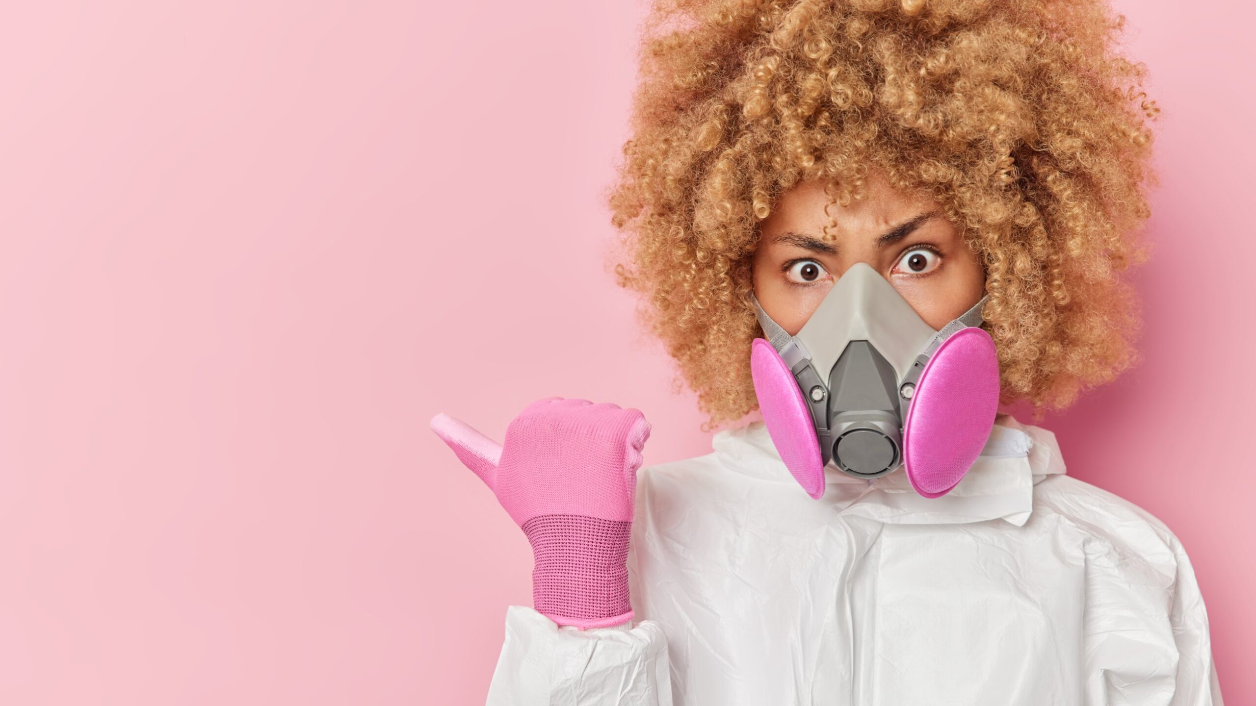Odor alarm: woman in a respirator mask on a pink background – Smell Crusher odor eliminators